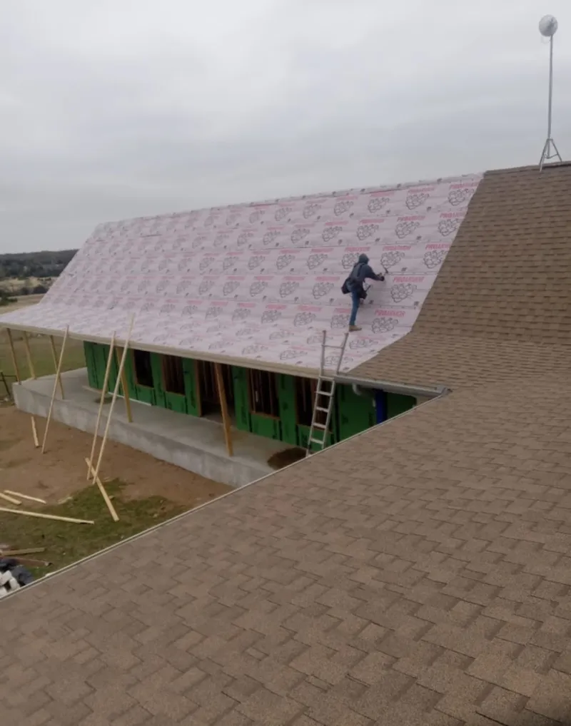 Worker preparing underlayment for a metal roof installation in North Lebanon